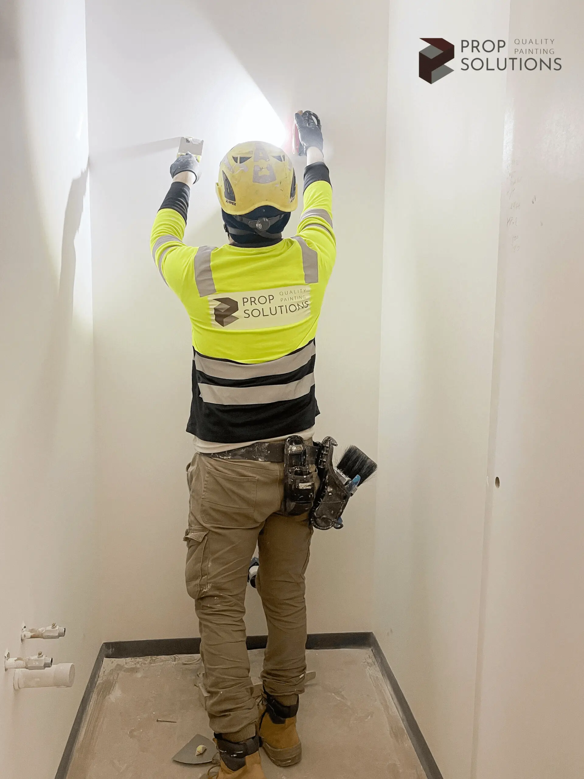 worker sanding an interior wall